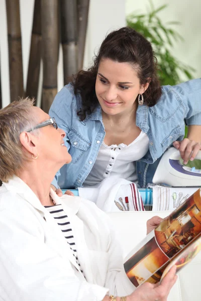 Mormor och inrikes helper att ha en chatt — Stockfoto