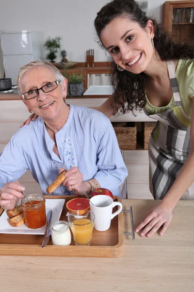 Μια ηλικιωμένη γυναίκα, έχοντας πρωινό με μια νεότερη γυναίκα — Φωτογραφία Αρχείου