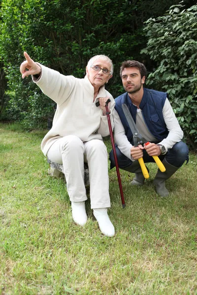 Senior weist Gärtner auf etwas hin — Stockfoto