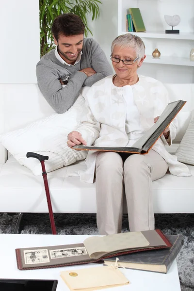 Elderly person looking at photos with son — Stock Photo, Image