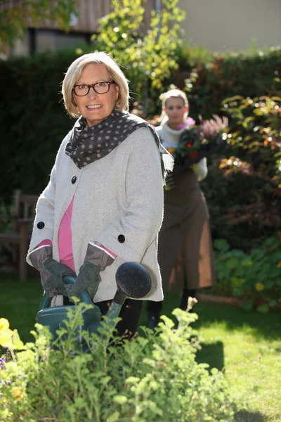 Jeune femme aidant dame âgée dans le jardin — Photo