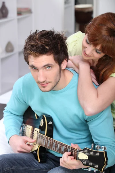 Jeune couple à la maison avec une guitare — Photo