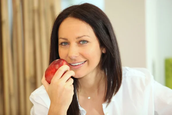 Una mujer comiendo una manzana — Foto de Stock