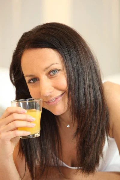 Kobieta ze szklanką soku pomarańczowego — Zdjęcie stockowe