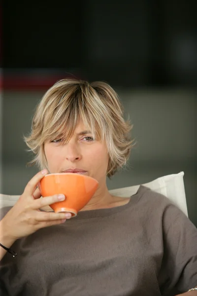 Mulher bebendo tee no sofá — Fotografia de Stock