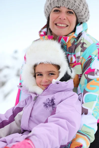 Madre e figlia sedute nella neve — Foto Stock