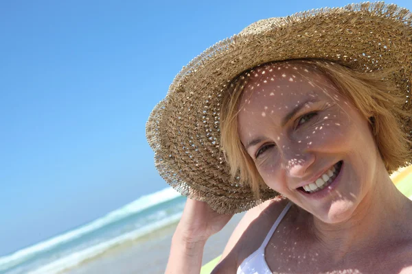 Frau am Strand mit Strohhut — Stockfoto