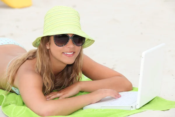 用的笔记本电脑在海滩上的年轻女子肖像 — 图库照片
