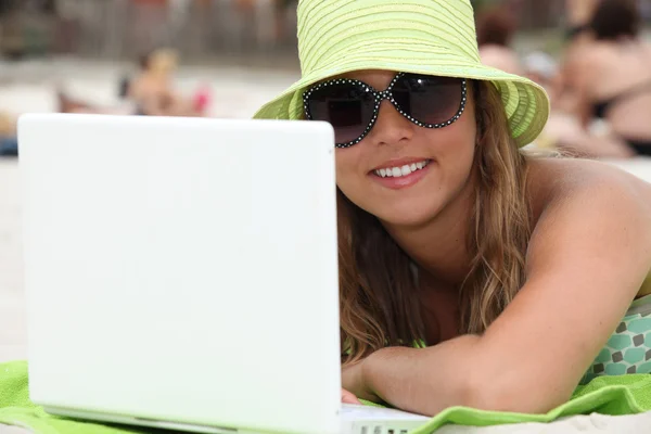 Femme à la plage en utilisant un ordinateur portable — Photo