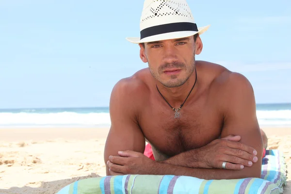 男子戴着帽子在海滩日光浴 — 图库照片