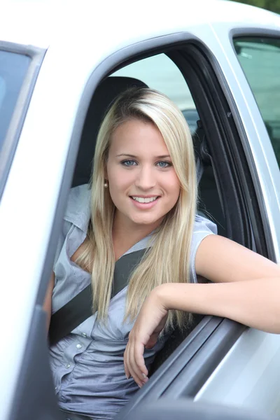 Jonge vrouw leunend uit auto raam — Stockfoto