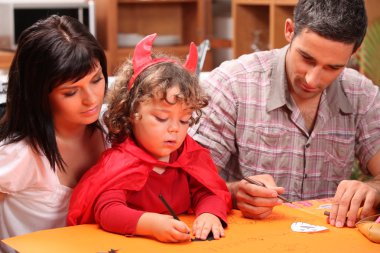 Mother and father with child disguised as devil clipart