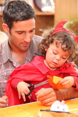 Dad with his child dressed as a devil for Halloween clipart