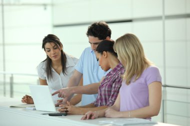 Group of young looking at a laptop computer clipart