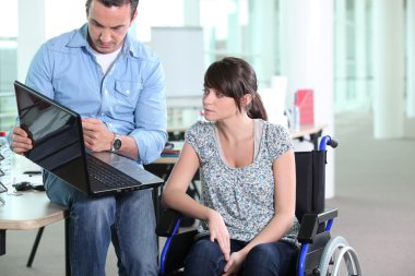 Young woman disabled with co-worker clipart