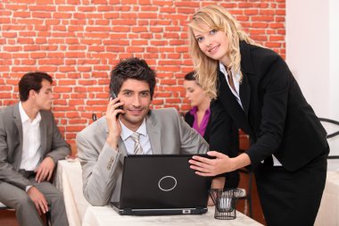 Waitress in a restaurant helping a man with his laptop computer clipart