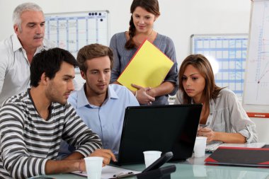 Young team working at a laptop clipart