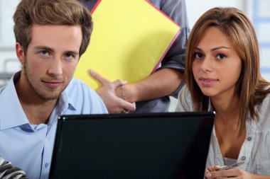 Interns sitting at a desk with computer clipart