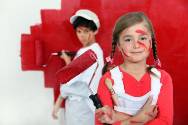 Children painting a wall red clipart