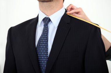 Businessman being measured for a suit clipart