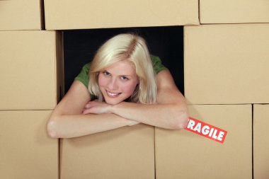 Woman stood amongst cardboard boxes clipart