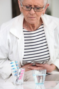 Woman about to take pain relievers clipart