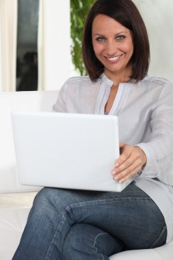 Woman using her laptop clipart