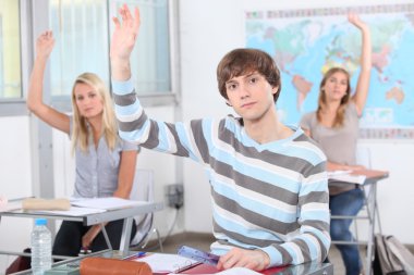 Students raising their hands in class clipart