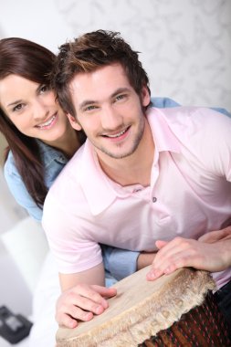 Young couple all smiles with djembe drum clipart