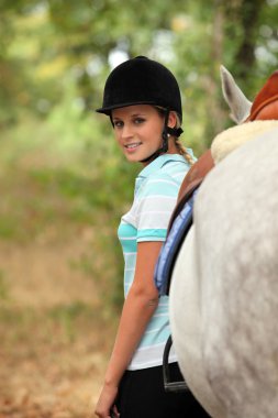 Woman standing next to her horse clipart