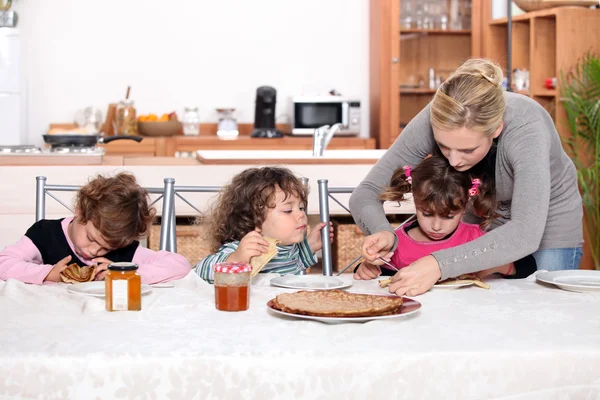 Маленькие дети едят блины — стоковое фото