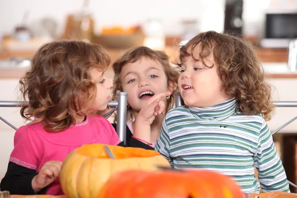 Kolme lasta keittiössä Halloween-aikaan — kuvapankkivalokuva