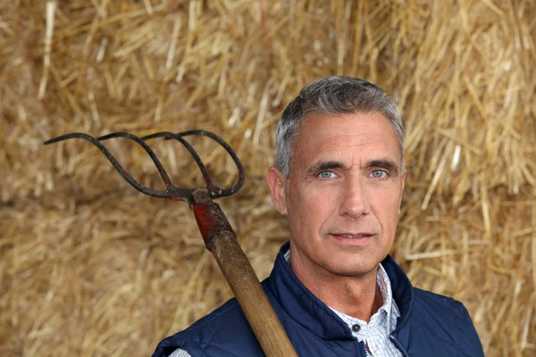 Farmer holding a pitchfork — Stock Photo, Image