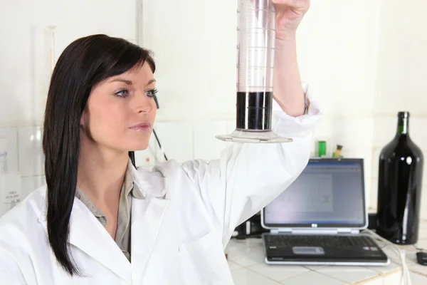 Female scientist analyzing wine — Stock Photo, Image