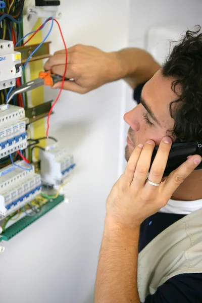 Eletricista trabalhando na placa de fusíveis — Fotografia de Stock