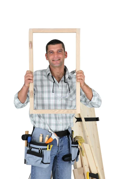 Carpinteiro mostrando moldura de madeira — Fotografia de Stock