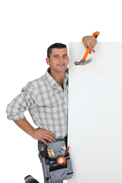 Handyman håller i en hammare och ett tomt tecken — Stockfoto