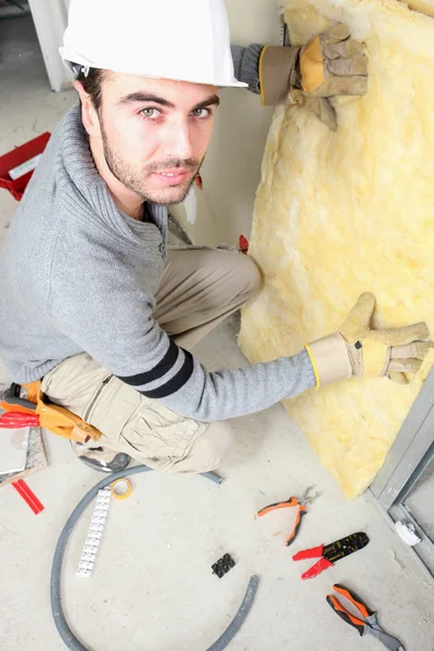Homem estofamento paredes com isolamento — Fotografia de Stock