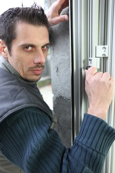 Hombre ajustando una cerradura de ventana — Foto de Stock