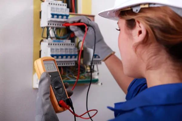 Kvinnliga elektriker tar behandlingen från säkringsdosan — Stockfoto