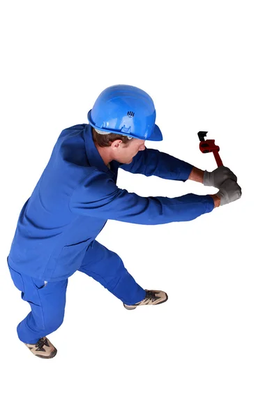 Vista superior de um encanador lutando com uma chave grande e encanamento — Fotografia de Stock