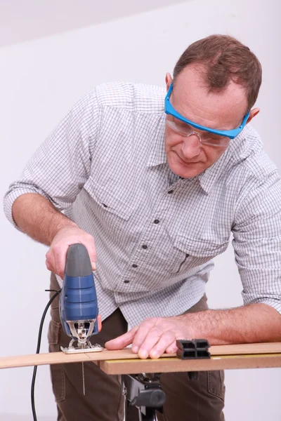 Carpenter with goggles using drill — Stock Photo, Image