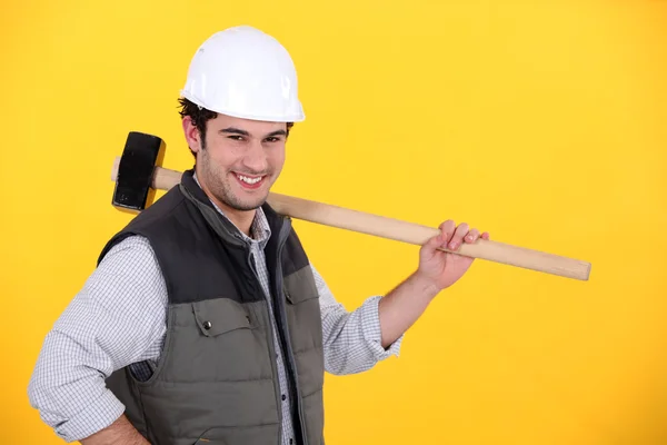 Happy builder carrying sledge-hammer — Stock Fotó