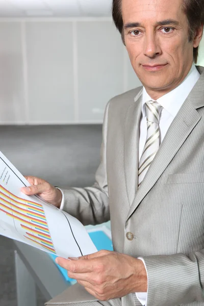 Businessman reading charts — Stock Photo, Image
