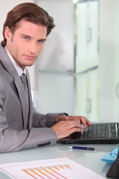 Jeune homme d'affaires sur ordinateur portable — Photo