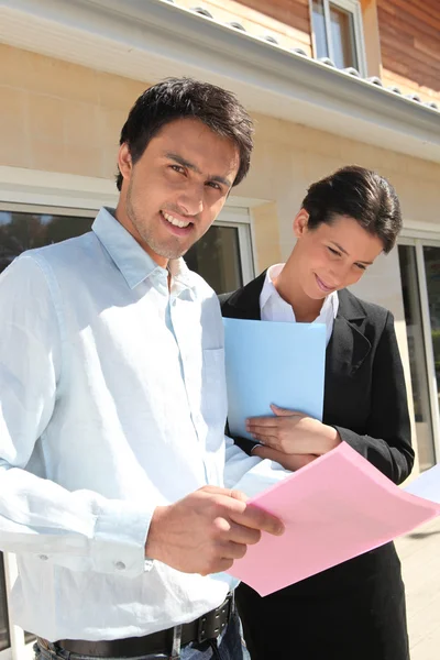 Realty promoters standing in front of a house — Stock Photo, Image