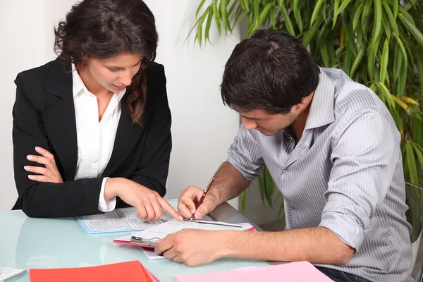 Empresária ajudando seu cliente a preencher papelada — Fotografia de Stock
