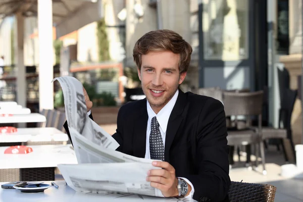 Young man cheerful reading newspaper — Stock Photo, Image