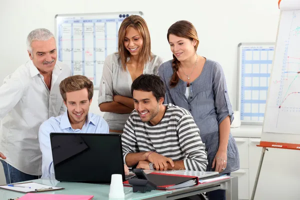 Co-workers gathered around computer screen — Stock Photo, Image