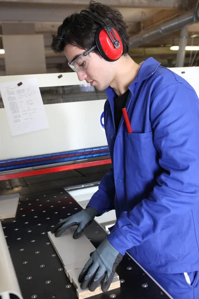 Работник фабрики носит наушники — стоковое фото